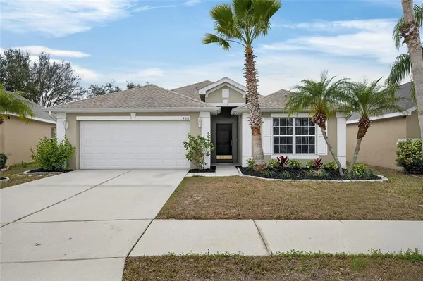 a view of a house with a yard and palm trees