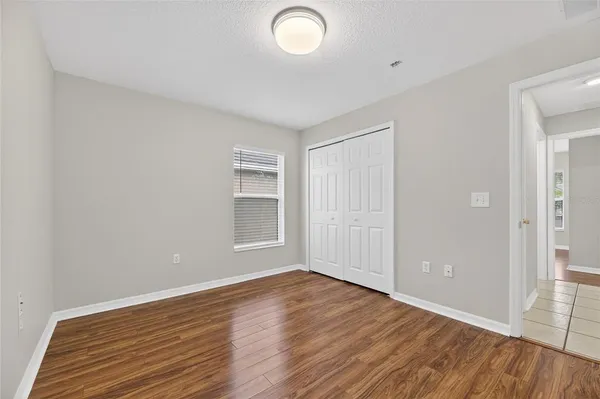 a view of an empty room and chandelier fan