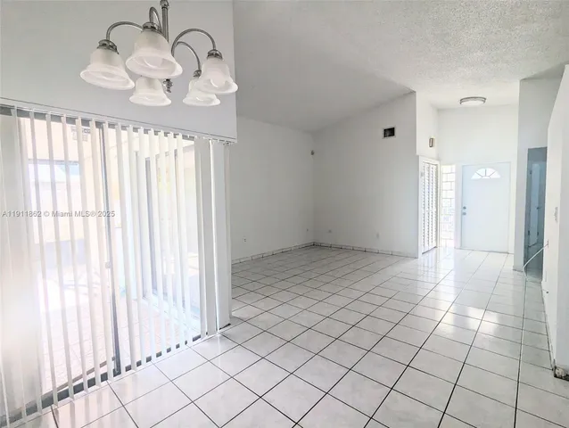 a view of a room with a large window and chandelier