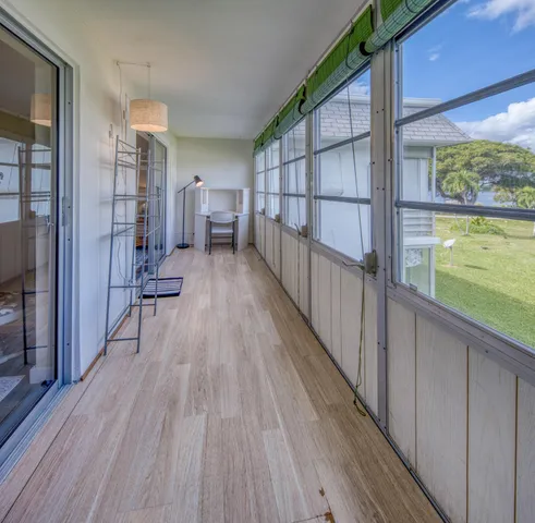 a view of a balcony with wooden floor and furniture