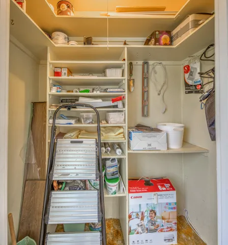 a utility room with fridge and rack