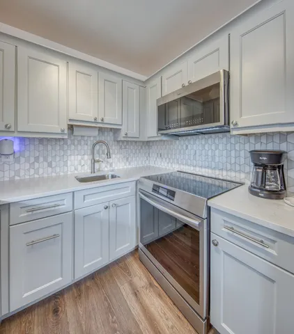 a kitchen with white cabinets stainless steel appliances and sink