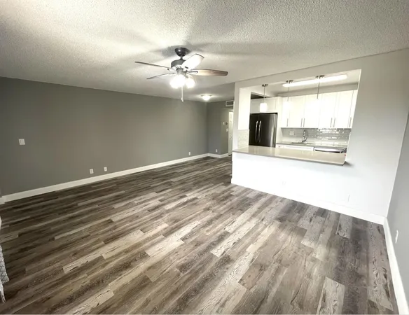 a view of a livingroom with an empty space and a ceiling fan