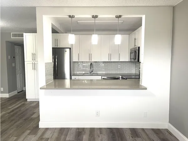 a kitchen with stainless steel appliances a refrigerator sink and microwave