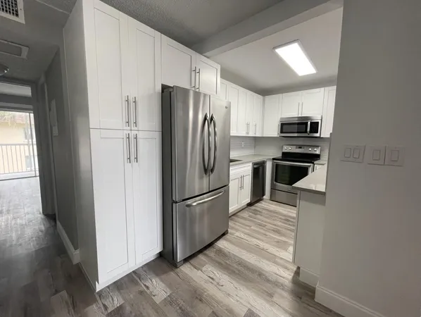 a large kitchen with kitchen island a counter space a sink and appliances
