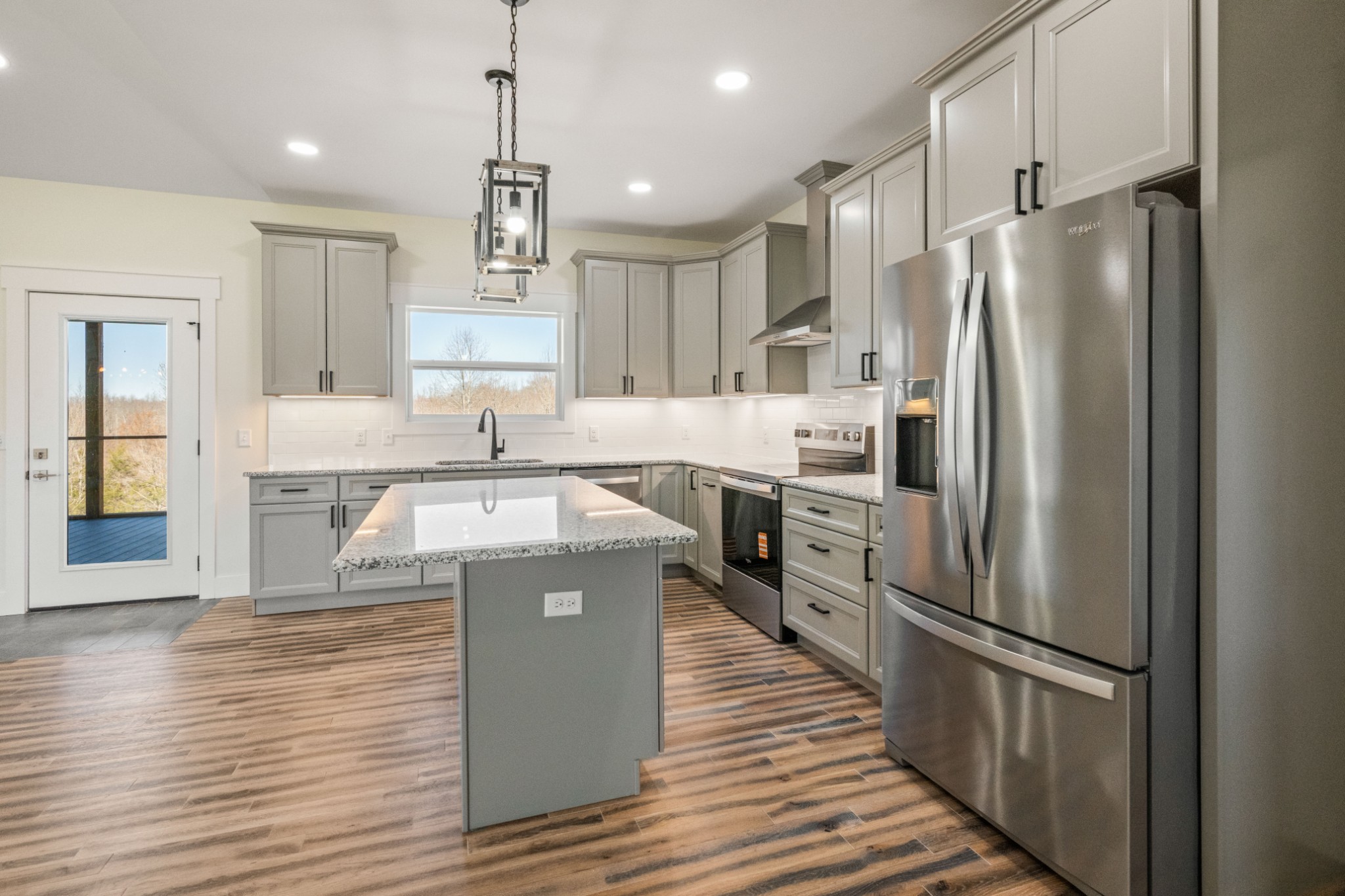 9345 Fox Hill Road Baxter, TN 38544 - Photo 28 of 54 a kitchen with stainless steel appliances granite countertop a refrigerator a stove and a wooden floors