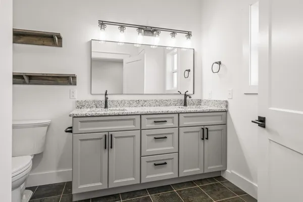 a sink with a granite countertop white vanity and a sink
