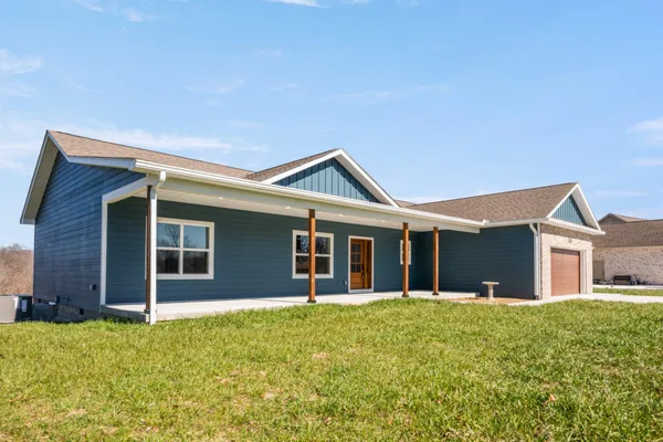 a view of a house with a yard and garage