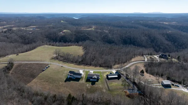 a aerial view of a house with a big yard and large tree