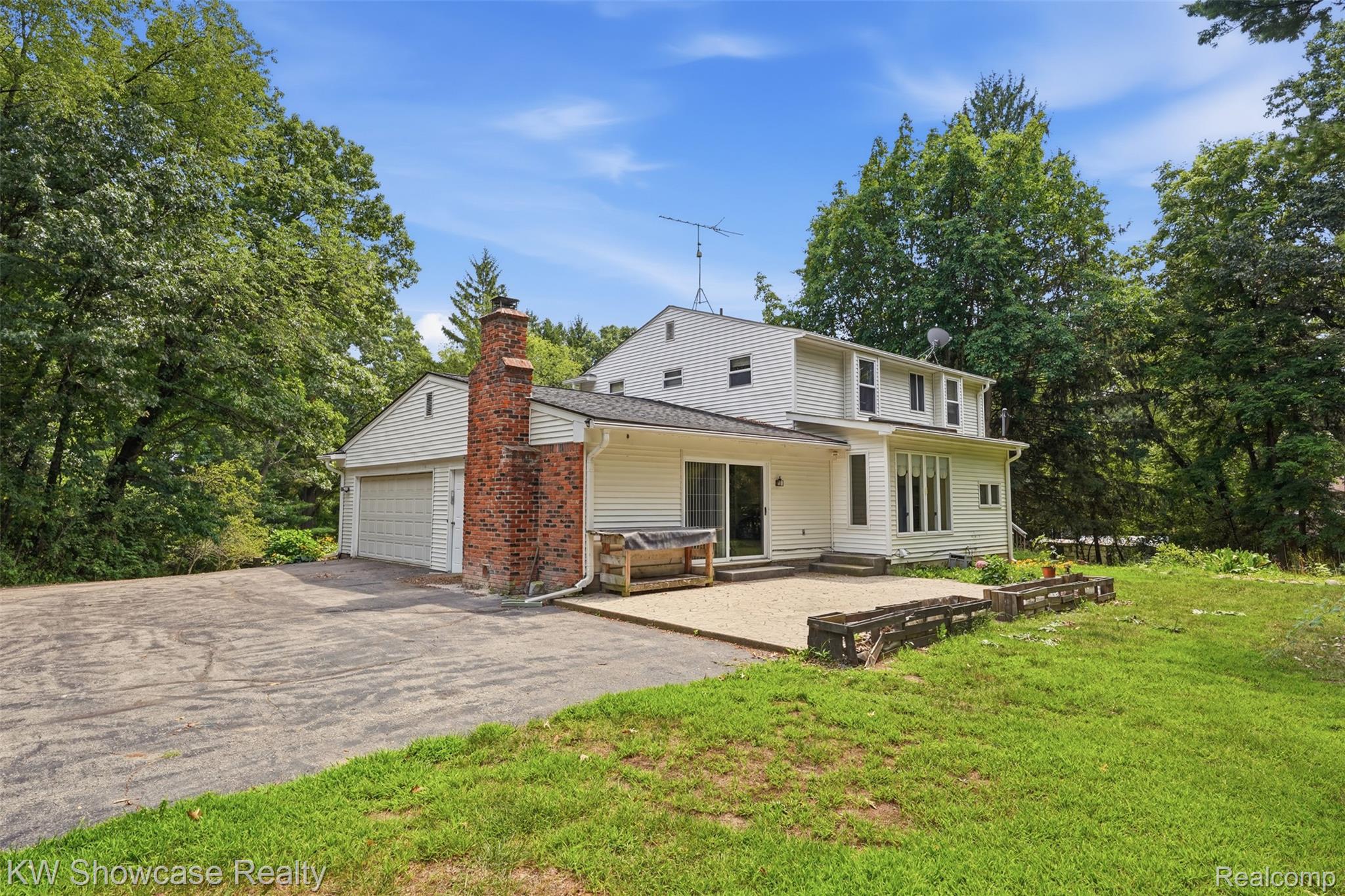 7125 Ridgewood Road Davisburg, MI 48350 - Photo 33 of 47 White siding exterior with a brick chimney and an attached garage