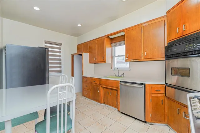 a kitchen with stainless steel appliances a sink dishwasher stove refrigerator and cabinets