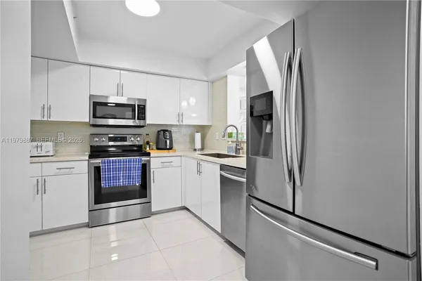 a kitchen with stainless steel appliances a refrigerator sink and microwave