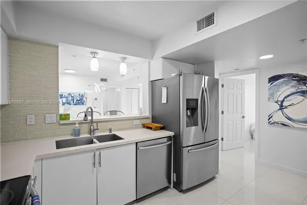 a kitchen with stainless steel appliances a refrigerator sink and cabinets