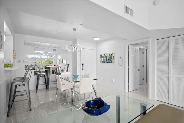 a room with lots of white furniture and a chandelier