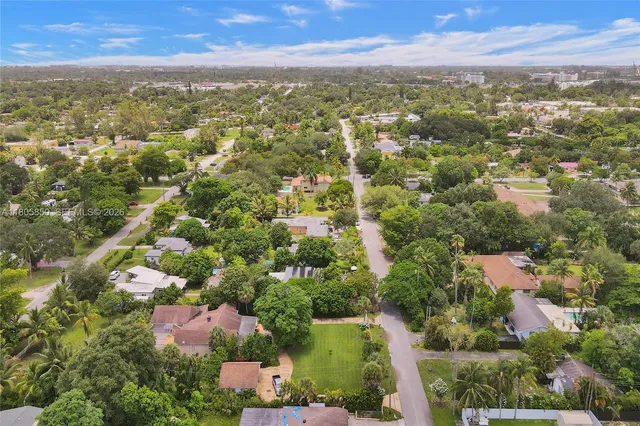 an aerial view of residential houses with city and outdoor space