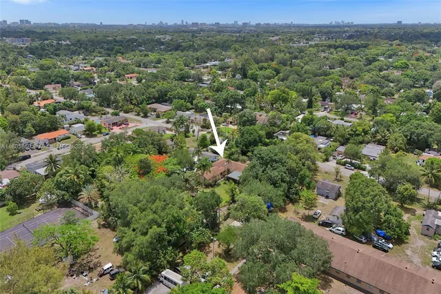 an aerial view of a houses with a lush green hillside