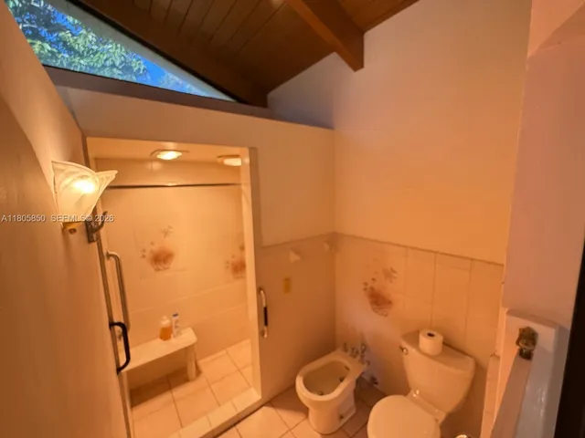 a bathroom with a granite countertop shower and a toilet