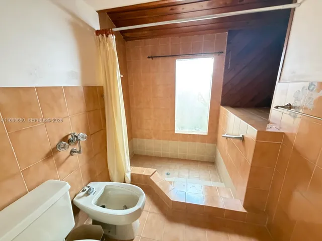 a bathroom with a tub and toilet