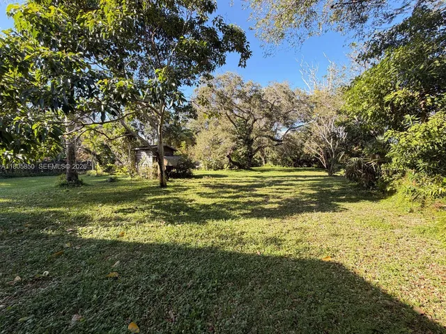 a view of a green field with wooden fence