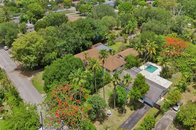 an aerial view of residential house with outdoor space and trees all around