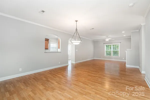 a view of empty room with wooden floor and ceiling fan