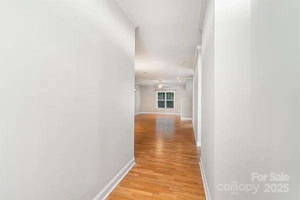 a view of a hallway with wooden floor and a chair