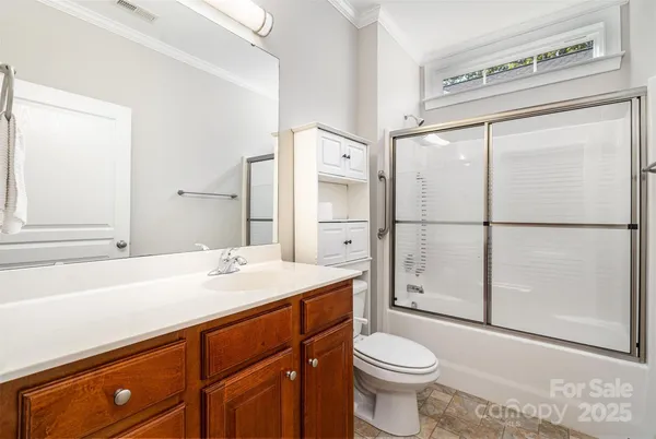 a bathroom with a sink toilet vanity and shower