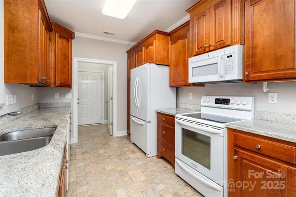 a kitchen with stainless steel appliances granite countertop a stove a sink and a refrigerator