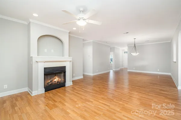 a view of empty room with wooden floor and fireplace
