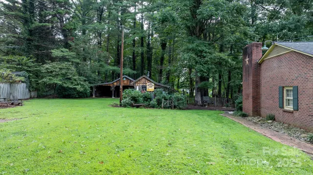a view of a backyard with potted plants and large trees