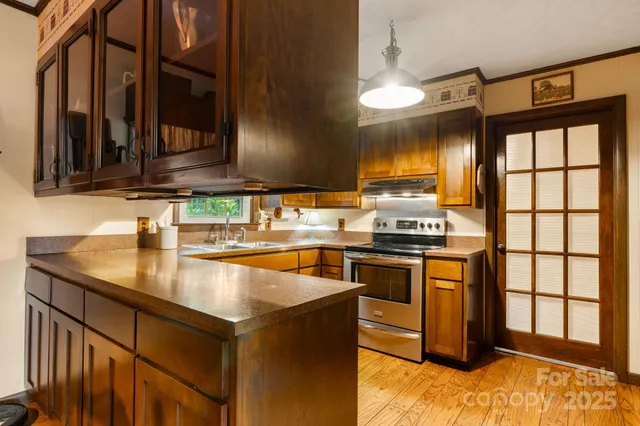 a kitchen with kitchen island granite countertop a sink cabinets and stainless steel appliances