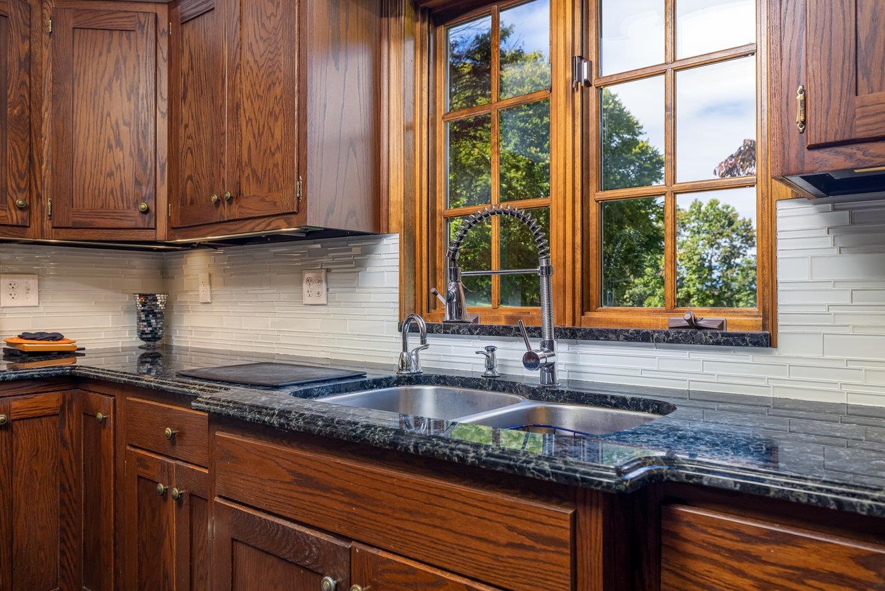 223 Fadley Road Weyers Cave, VA 24486 - Photo 15 of 59 a kitchen with granite countertop wooden cabinets a sink and a window
