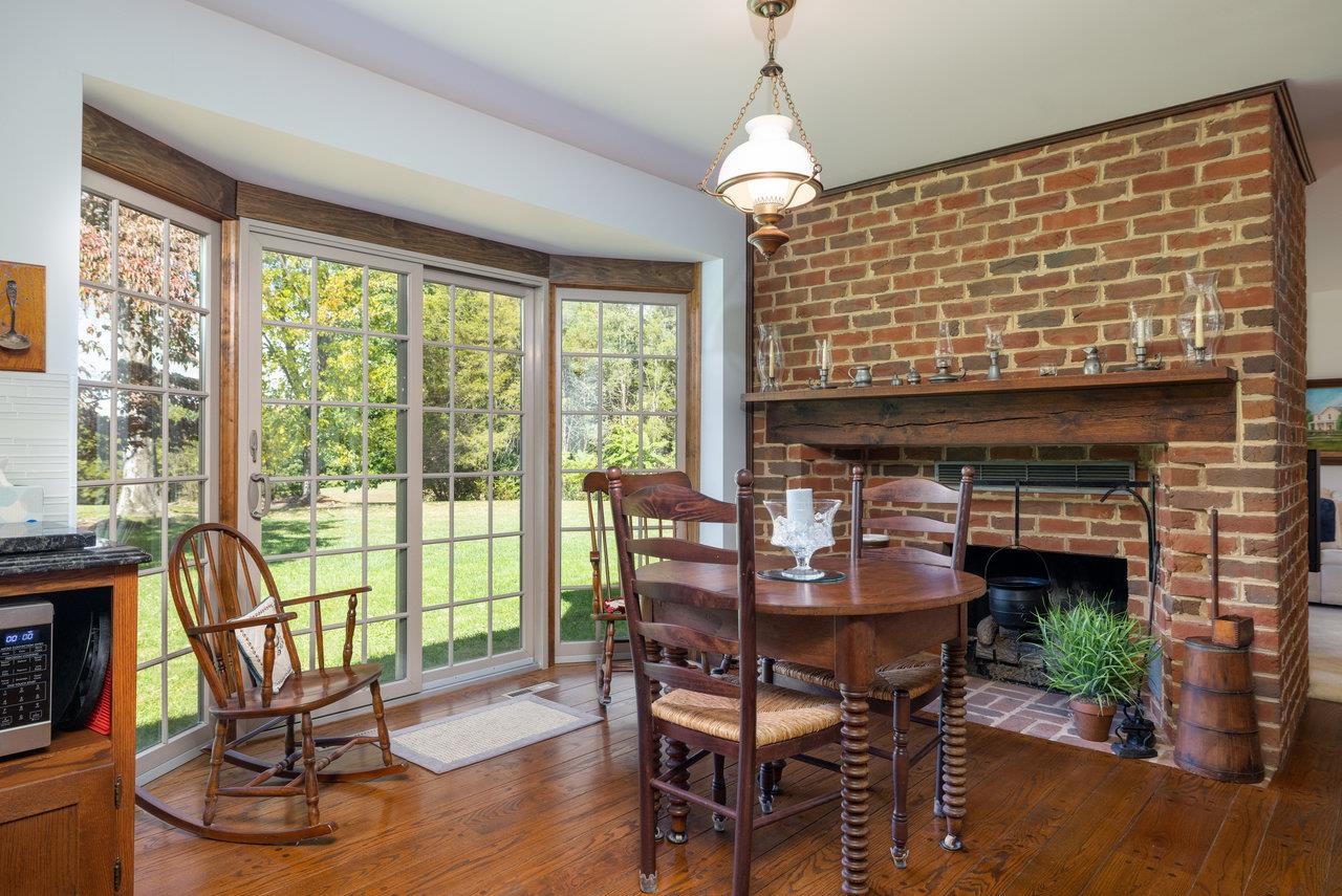 223 Fadley Road Weyers Cave, VA 24486 - Photo 18 of 59 a dining room with furniture wooden floor a flat screen tv and a fireplace