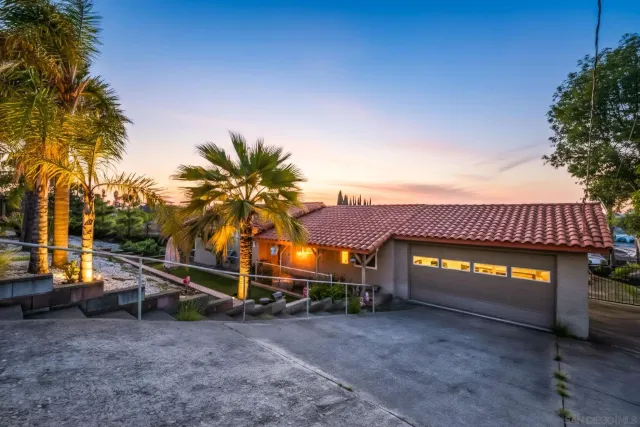 a view of a house with a patio and a yard