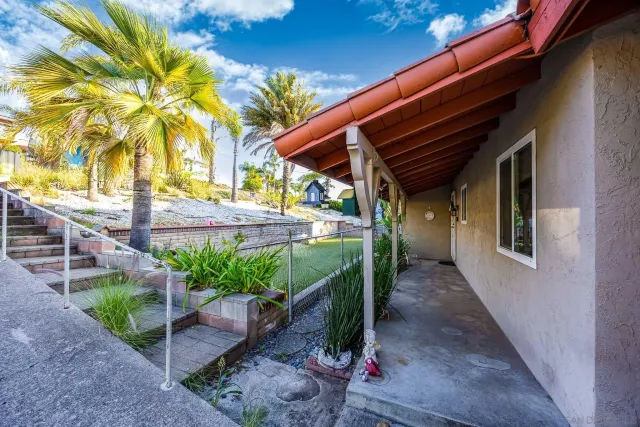 a backyard of a house with a garden and outdoor seating