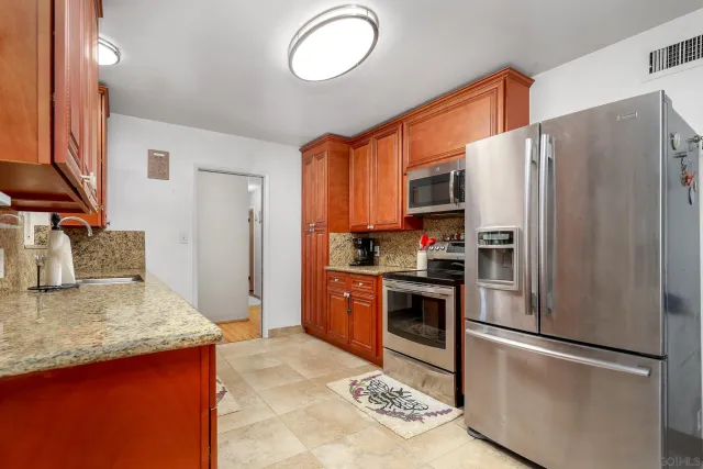 a kitchen with stainless steel appliances granite countertop a refrigerator stove and oven