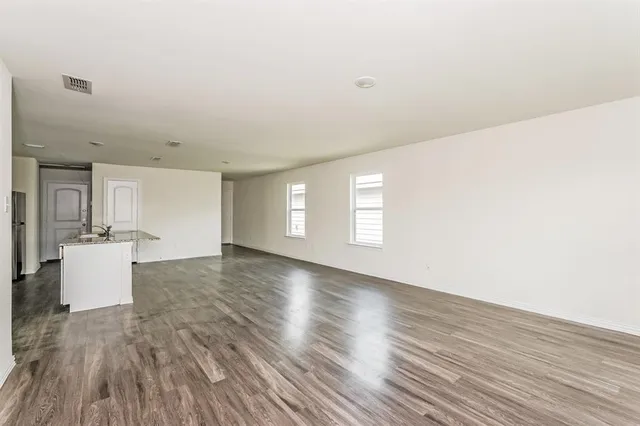 a view of a kitchen with wooden floor and a window