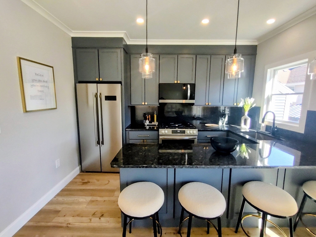 93 Grove Street, Unit 1R Fall River, MA 02720 - Photo 1 of 21 a kitchen with stainless steel appliances a dining table chairs refrigerator and sink