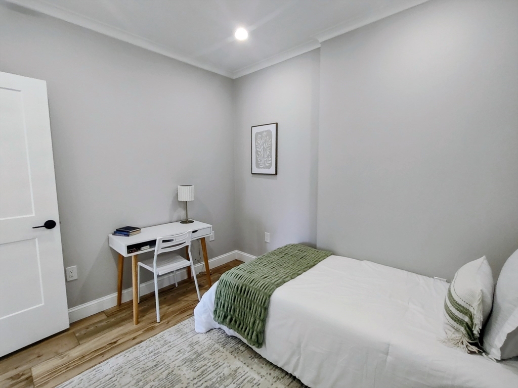 93 Grove Street, Unit 1R Fall River, MA 02720 - Photo 13 of 21 a bedroom with a bed and a chair