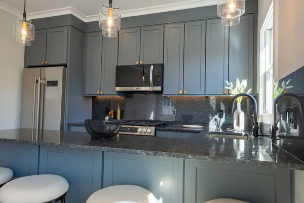 a kitchen with stainless steel appliances granite countertop a sink refrigerator stove and microwave