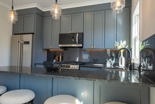 a kitchen with stainless steel appliances granite countertop a sink refrigerator stove and microwave