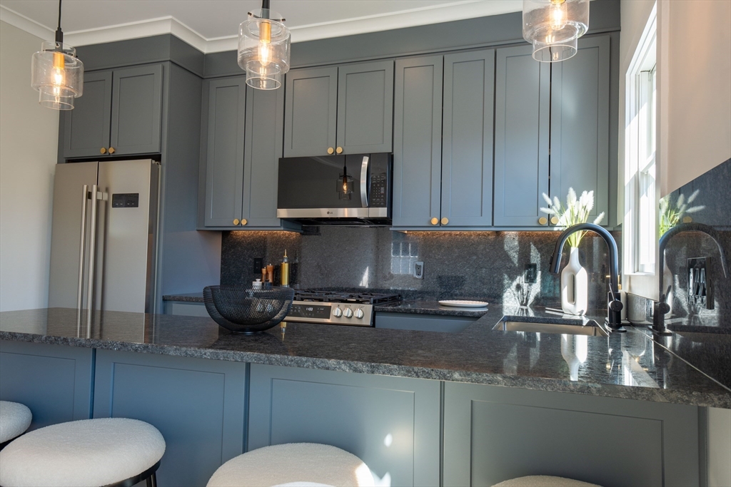93 Grove Street, Unit 1R Fall River, MA 02720 - Photo 2 of 21 a kitchen with stainless steel appliances granite countertop a sink refrigerator stove and microwave