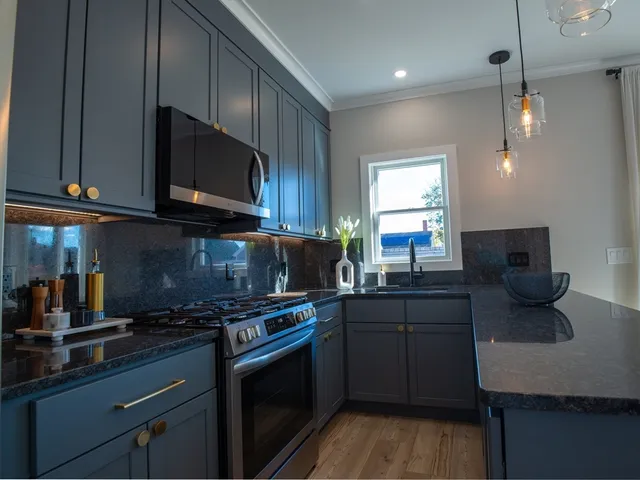 a kitchen with stainless steel appliances a stove a sink a microwave a refrigerator and cabinets