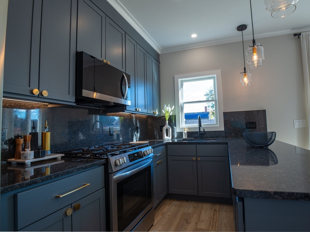 93 Grove Street, Unit 1R Fall River, MA 02720 - Photo 3 of 21 a kitchen with stainless steel appliances a stove a sink a microwave a refrigerator and cabinets