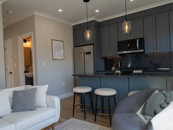 a kitchen with furniture a refrigerator and a stove top oven