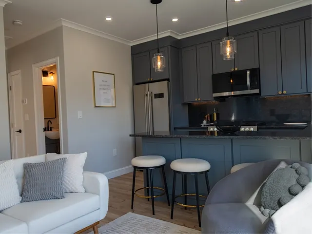 a kitchen with furniture a refrigerator and a stove top oven