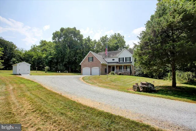 a front view of a house with a yard and trees