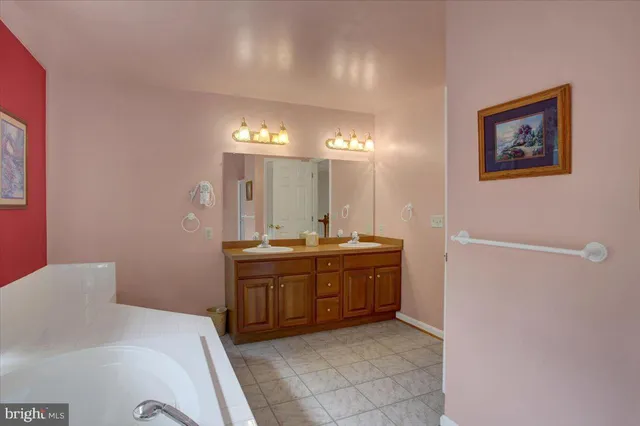 a spacious bathroom with a granite countertop sink a mirror and a bathtub