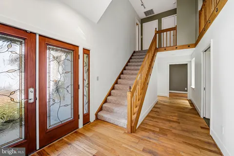 a view of a hallway with wooden floor staircase and windows