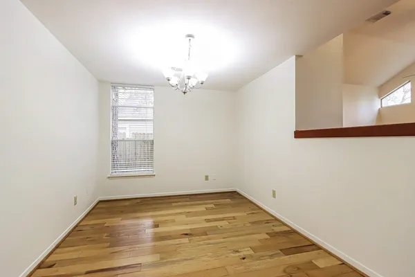 an empty room with wooden floor and window
